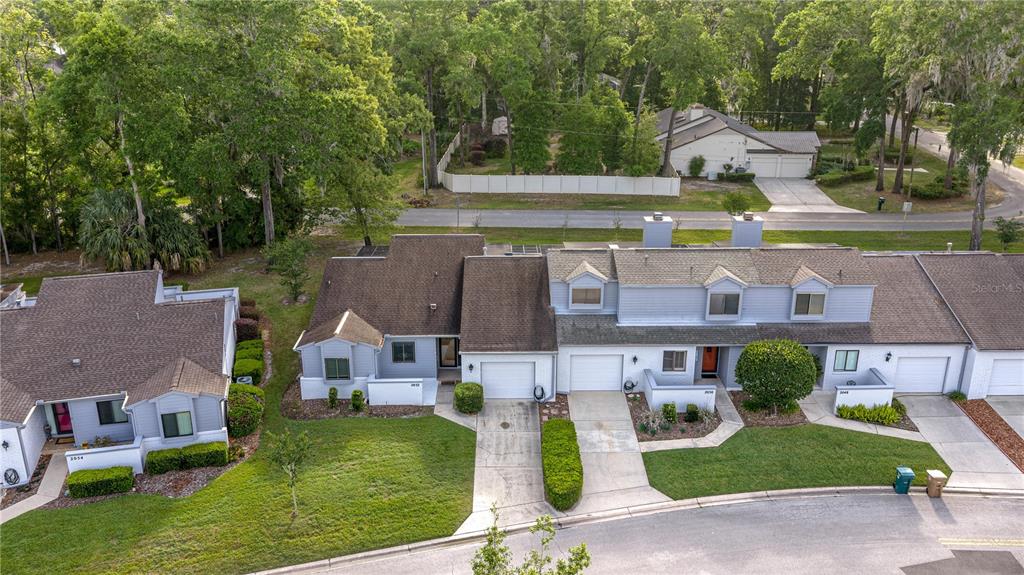 An aerial view shows a row of attached townhomes with garages and manicured lawns — 2050 SE 37TH COURT CIRCLE, OCALA, FL