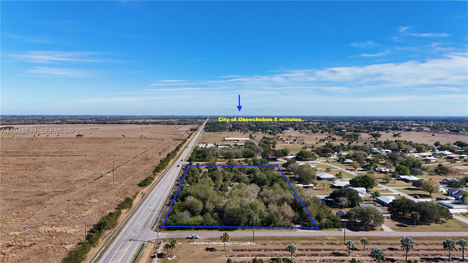 An aerial view shows a rectangular, tree-covered plot of land adjacent to a highway — 8636 W Hwy 70, Okeechobee FL 34974, OKEECHOBEE, FL