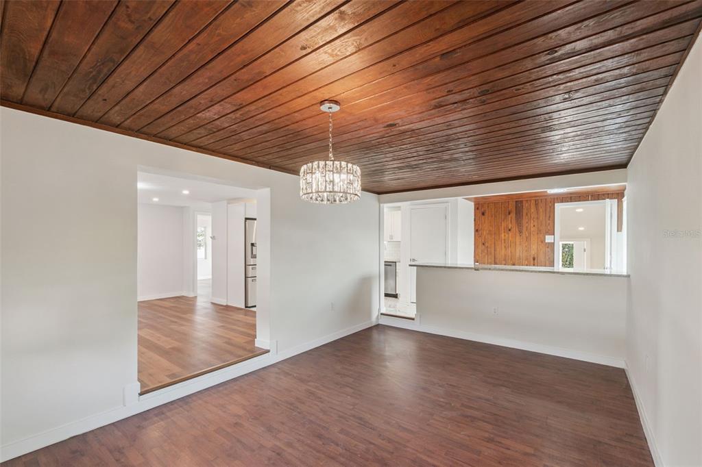 A dining room with a wood-plank ceiling, a crystal chandelier, and a breakfast bar — 126 KENSINGTON ROAD, DELAND, FL