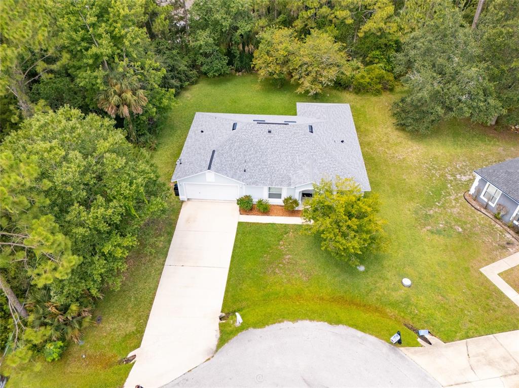An aerial view shows a single-story house with a gray roof and concrete driveway — 19 BURRELL PLACE, PALM COAST, FL