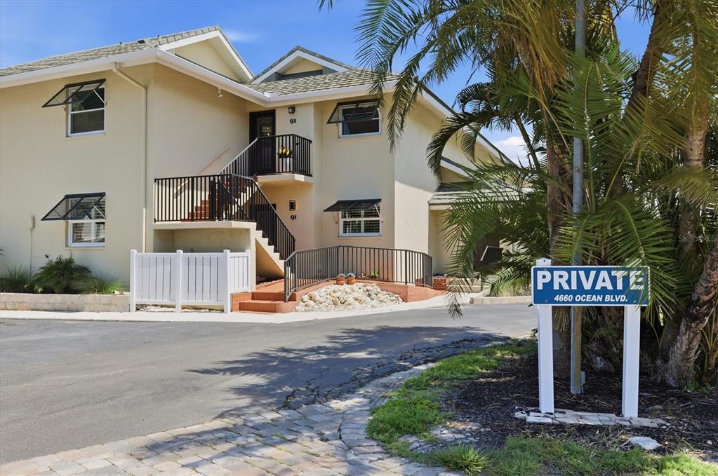 A two-story stucco building with exterior staircases and a private sign in the foreground — 4660 OCEAN BOULEVARD UNIT Q2, SARASOTA, FL