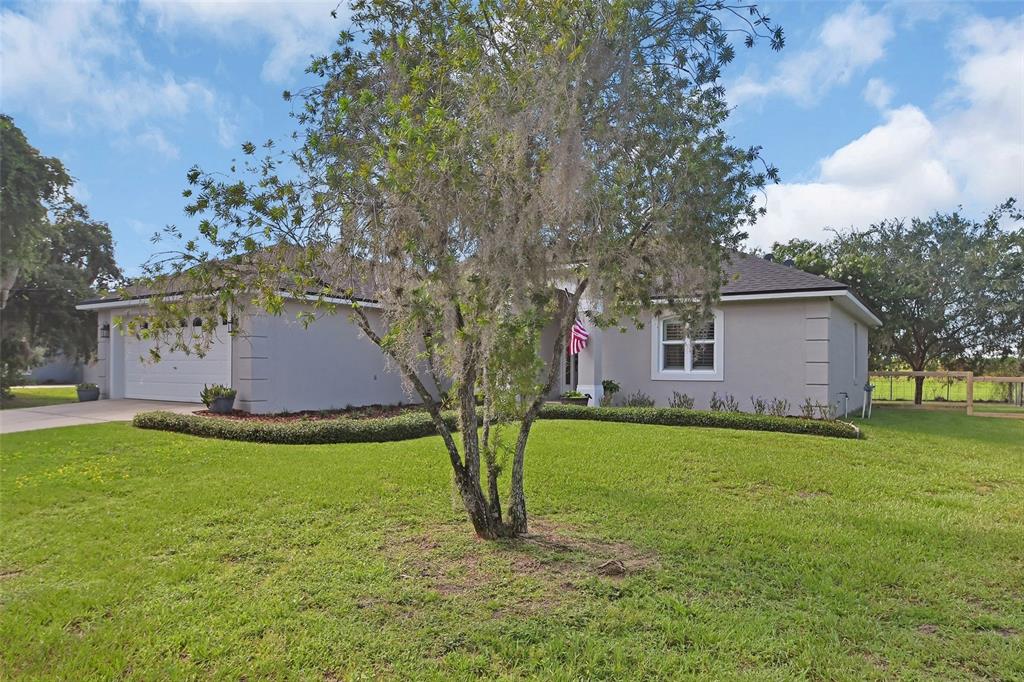 A single-story house with a gray exterior, a two-car garage, and a large front lawn — 523 KONOMAC LAKE DRIVE, DEBARY, FL