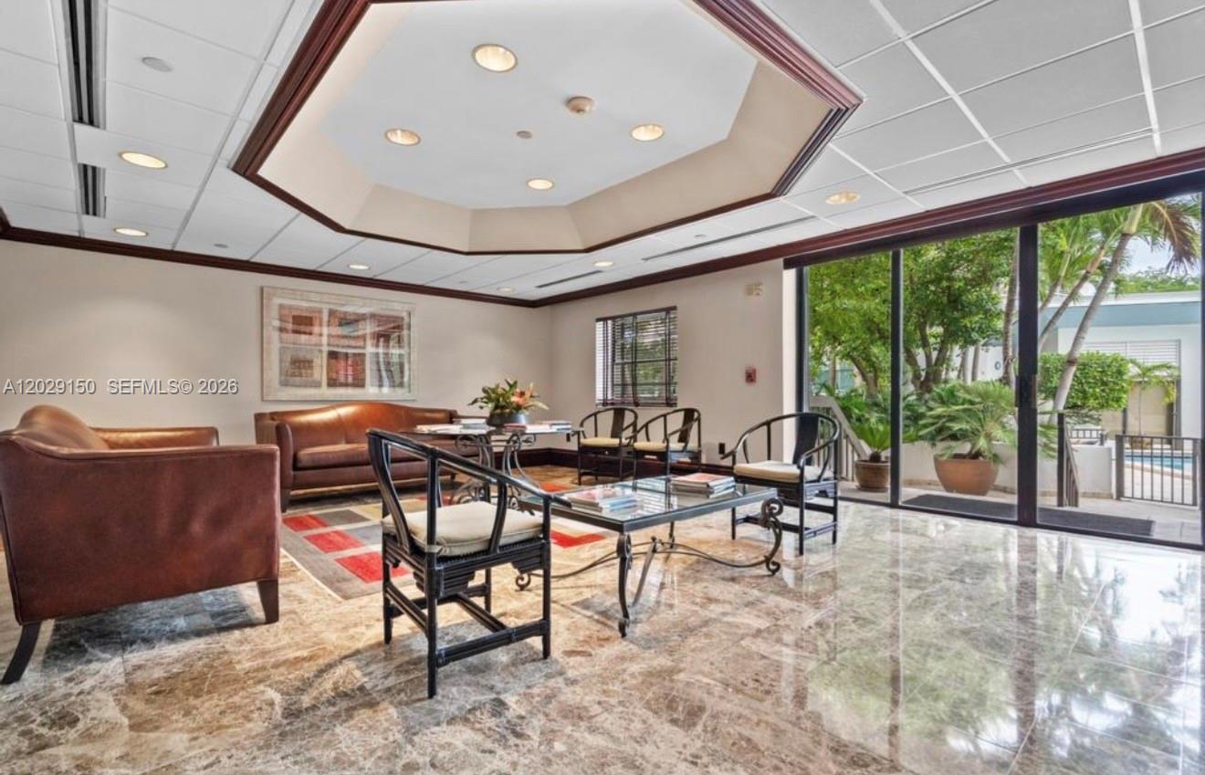 A living room with marble floors, a tray ceiling, and sliding glass doors to a patio — 151 SE 15th Rd # 502, Miami FL 33129, MIAMI, FL
