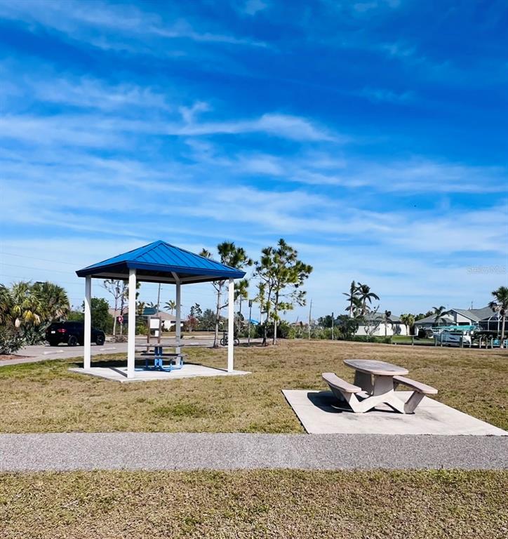 A park area features a blue-roofed pavilion and a picnic table on concrete pads — 9406 IMPALA CIRCLE, PORT CHARLOTTE, FL