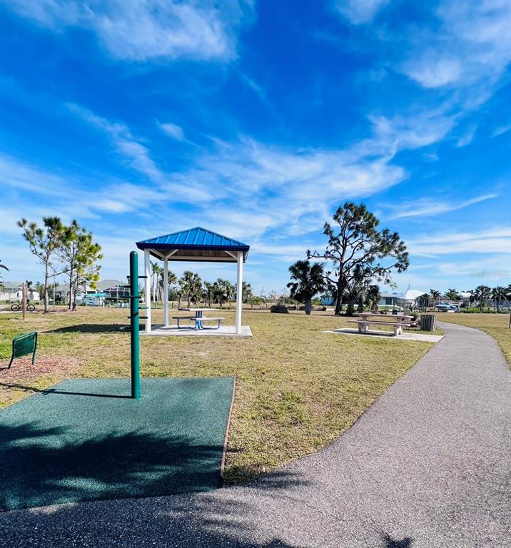 A park features a covered picnic pavilion, a paved walking path, and exercise equipment — 9406 IMPALA CIRCLE, PORT CHARLOTTE, FL