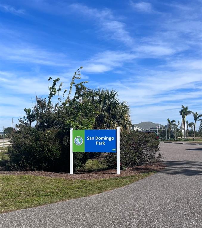 A blue and green sign for San Domingo Park stands in front of lush landscaping — 9406 IMPALA CIRCLE, PORT CHARLOTTE, FL