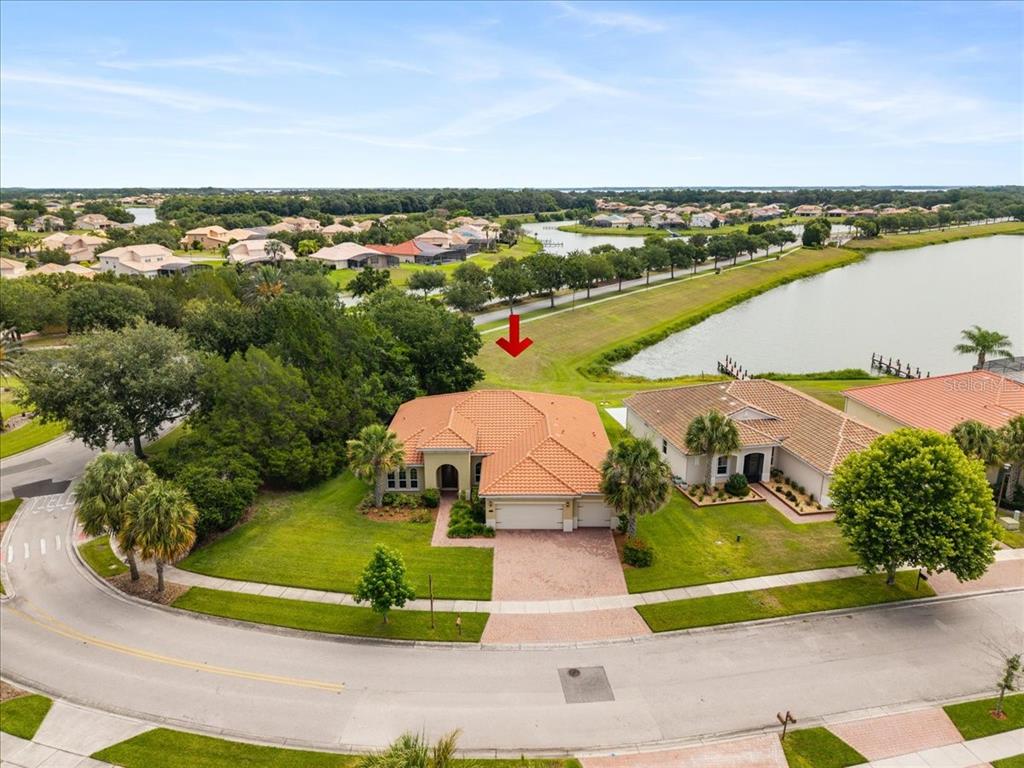 An aerial view shows a single-story house with a tile roof near a lake — 3801 BOWFIN TRAIL, KISSIMMEE, FL