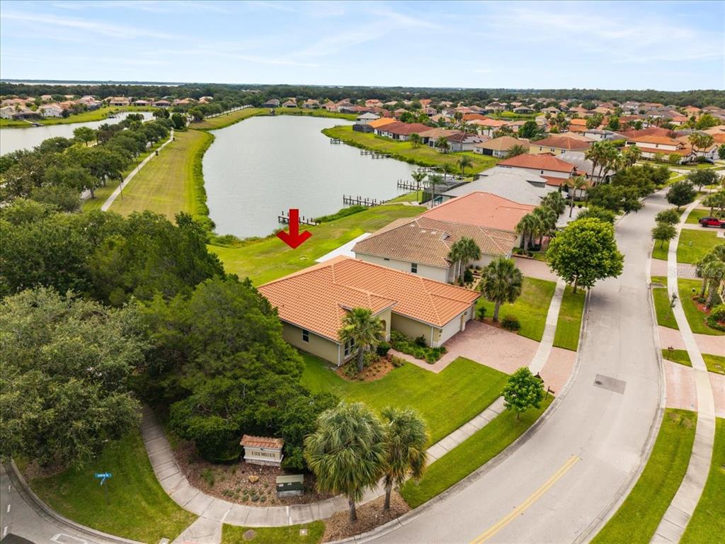 An aerial view of a suburban house with a tile roof near a lake — 3801 BOWFIN TRAIL, KISSIMMEE, FL