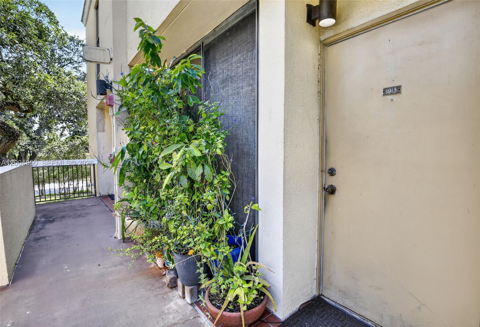 An exterior view of a building entrance with a door numbered 1913 and potted plants — 2931 SW 87th Ter # 1913, Davie FL 33328, DAVIE, FL