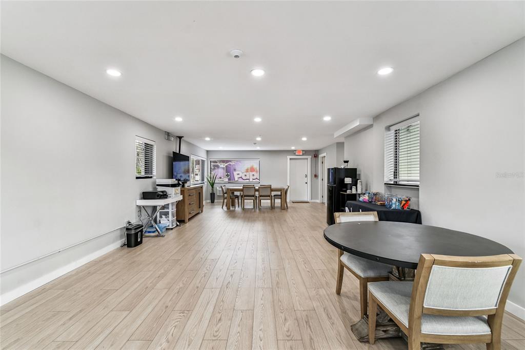 A spacious, light-filled room features light wood-look flooring, recessed lighting, and multiple dining areas — 830 W KENNEDY BOULEVARD, TAMPA, FL