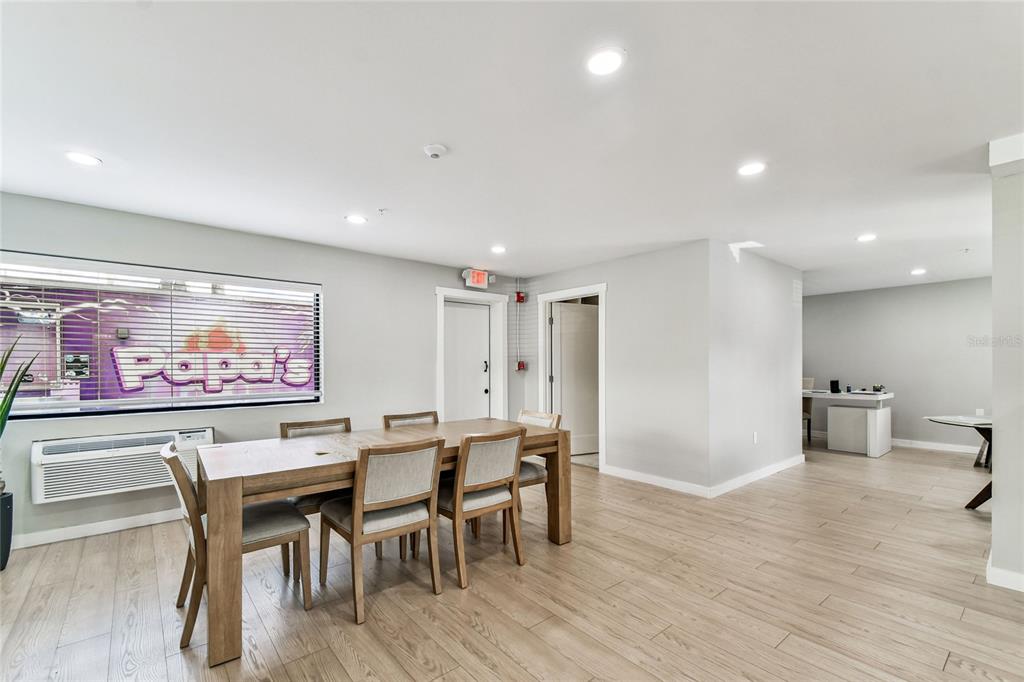 A dining room with a wooden table, chairs, light wood flooring, and a window view — 830 W KENNEDY BOULEVARD, TAMPA, FL