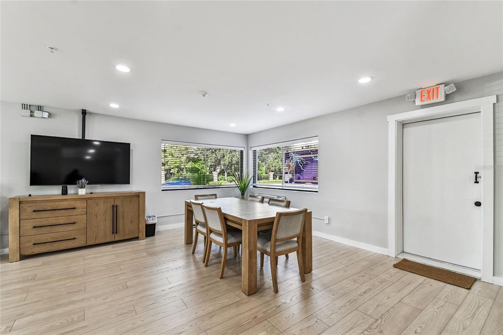 A dining area features a wooden table, four chairs, a media console, and an exit door — 830 W KENNEDY BOULEVARD, TAMPA, FL