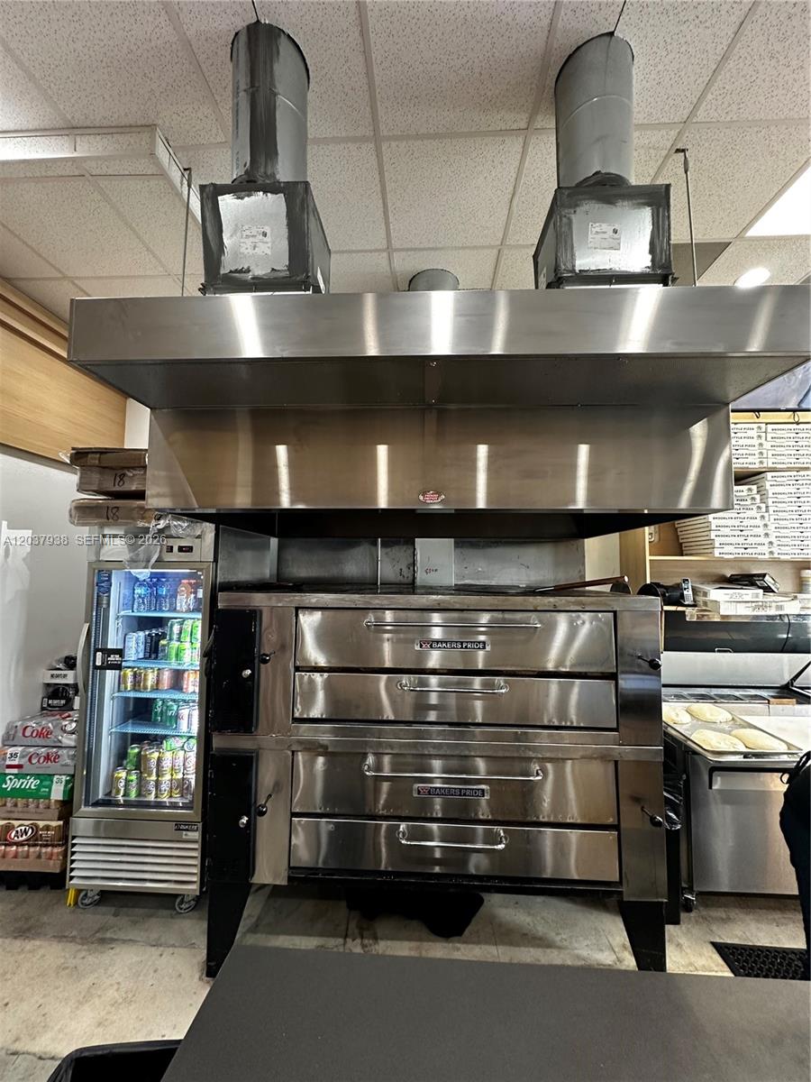 A commercial kitchen features a large stainless steel Bakers Pride pizza oven under a vent hood — Confidential, Coconut Grove FL 33133, COCONUT GROVE, FL