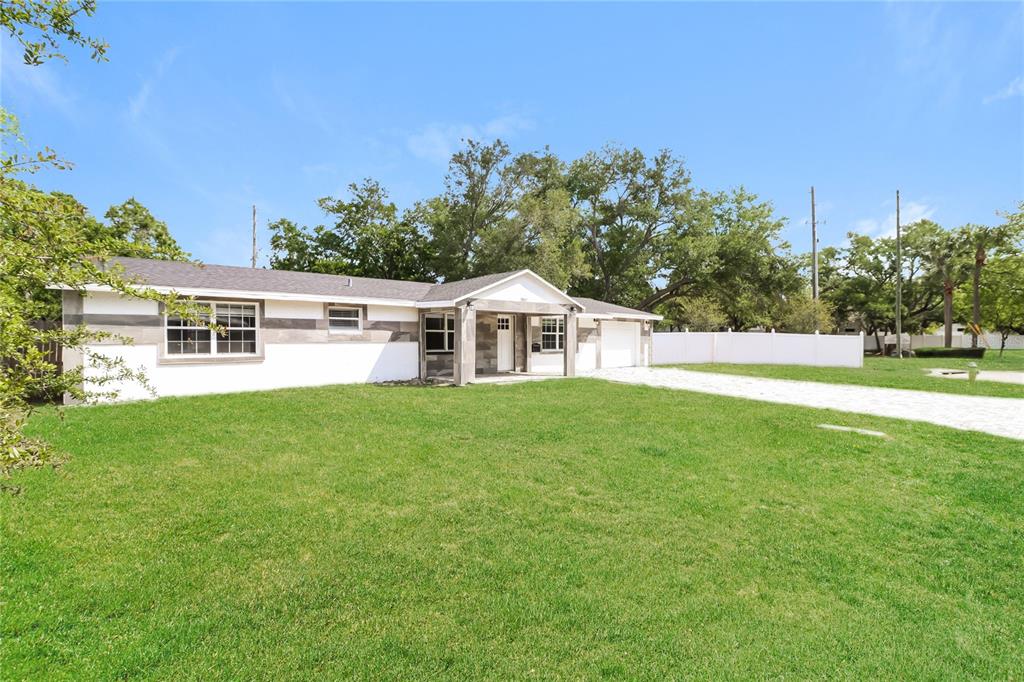 A single-story house with a white exterior, gray accents, and a large front lawn — 3147 36TH AVENUE N, ST PETERSBURG, FL
