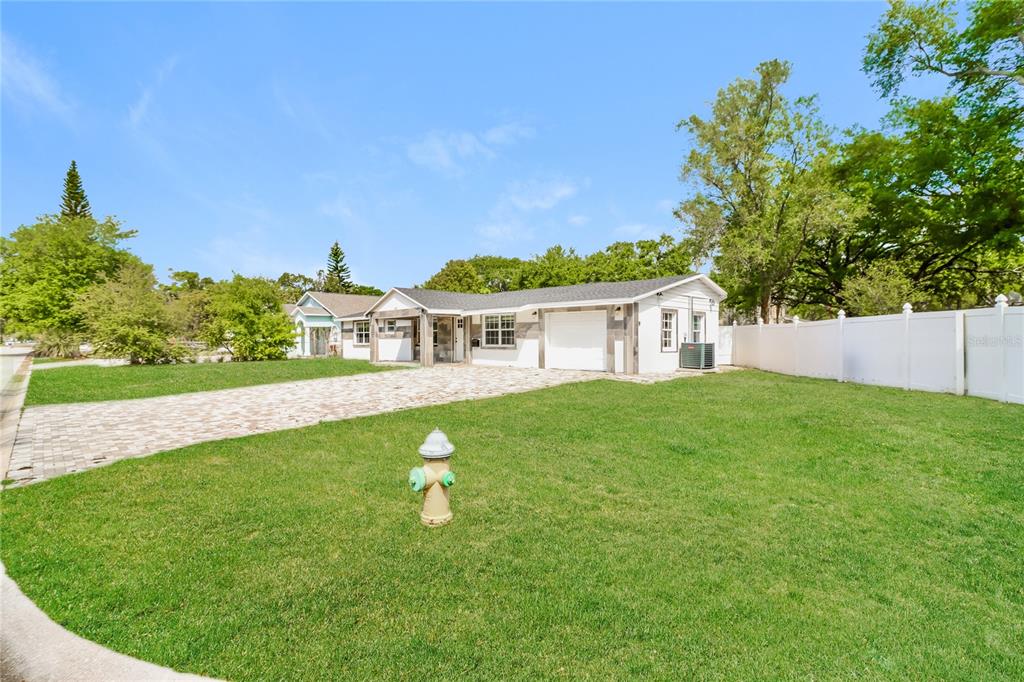 A single-story house with a white exterior, a paved driveway, and a front yard fire hydrant — 3147 36TH AVENUE N, ST PETERSBURG, FL