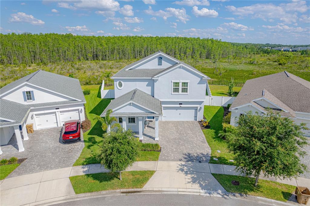 An aerial view shows a two-story house with a paved driveway and attached garage — 3032 PRELUDE LANE, KISSIMMEE, FL
