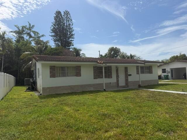 A single-story house with a tile roof, white exterior walls, and a front lawn — 210 NE 5th Avenue, Dania Beach FL 33004, DANIA BEACH, FL