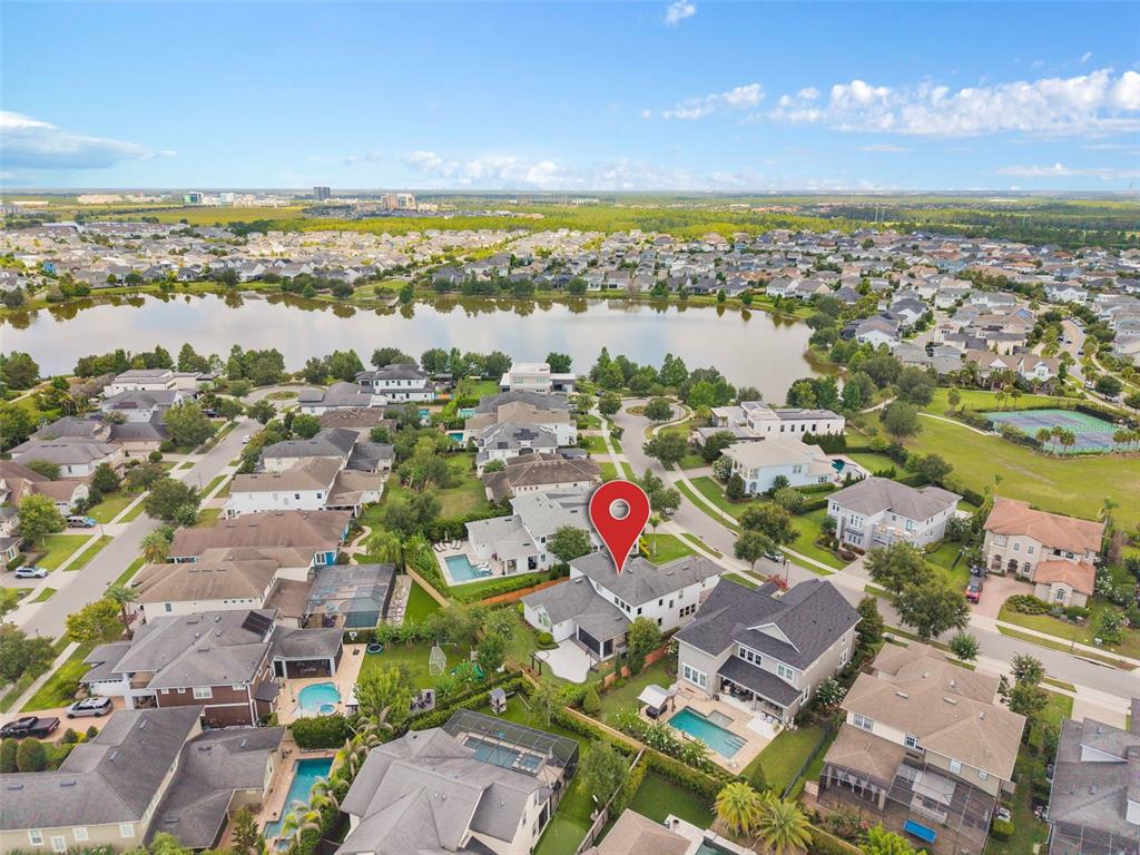 An aerial view shows a residential neighborhood with houses, swimming pools, and a large lake — 9462 BECKER COURT, ORLANDO, FL