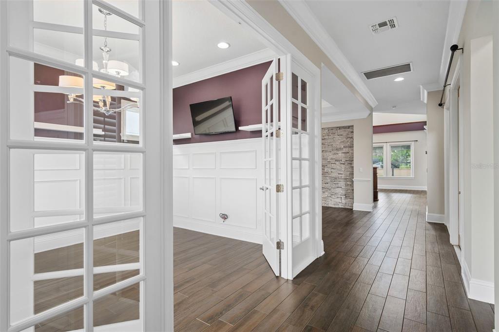 A room with white wainscoting and a purple wall is viewed through open French doors — 9462 BECKER COURT, ORLANDO, FL