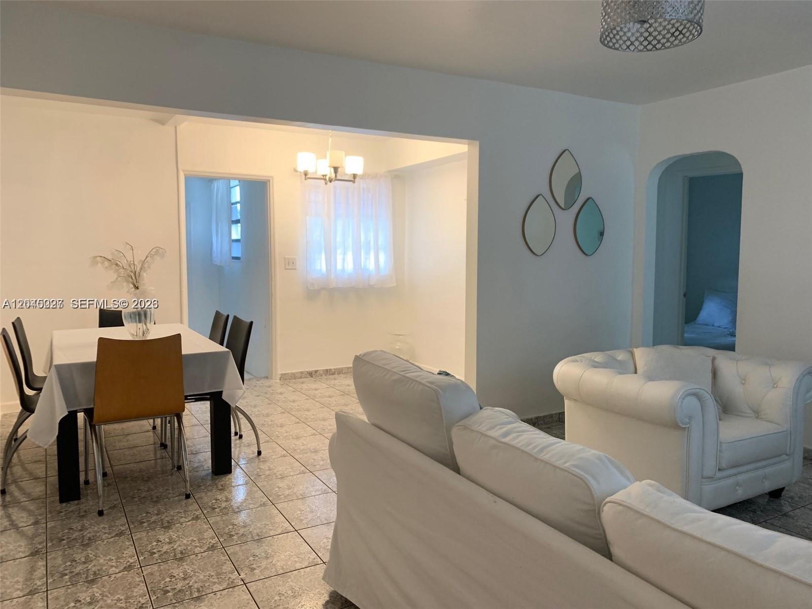 An empty room features white walls, a large window with sheer curtains, and tiled flooring — 2131 Arthur St # 0, Hollywood FL 33020, HOLLYWOOD, FL