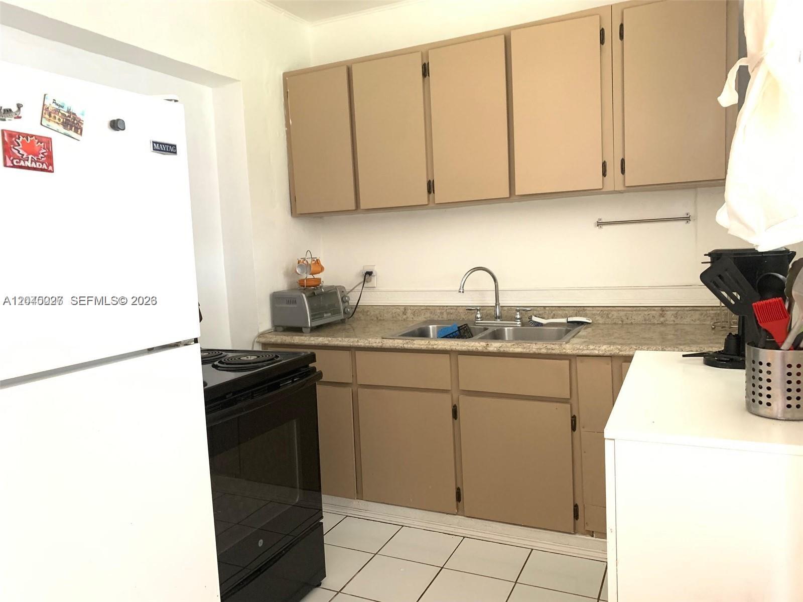 An empty room features white walls, a tiled floor, and a decorative ceiling light fixture — 2131 Arthur St # 0, Hollywood FL 33020, HOLLYWOOD, FL