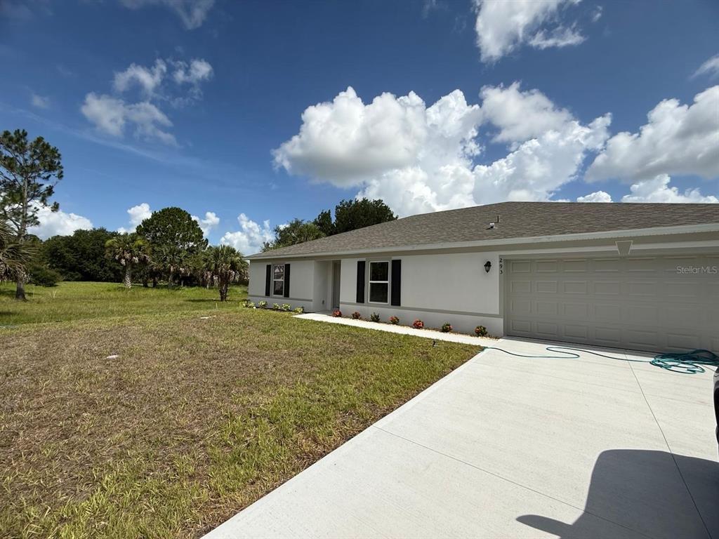 A single-story house with a white stucco exterior, a gray roof, and a concrete driveway — 293 LAFLEUR STREET SW, PALM BAY, FL