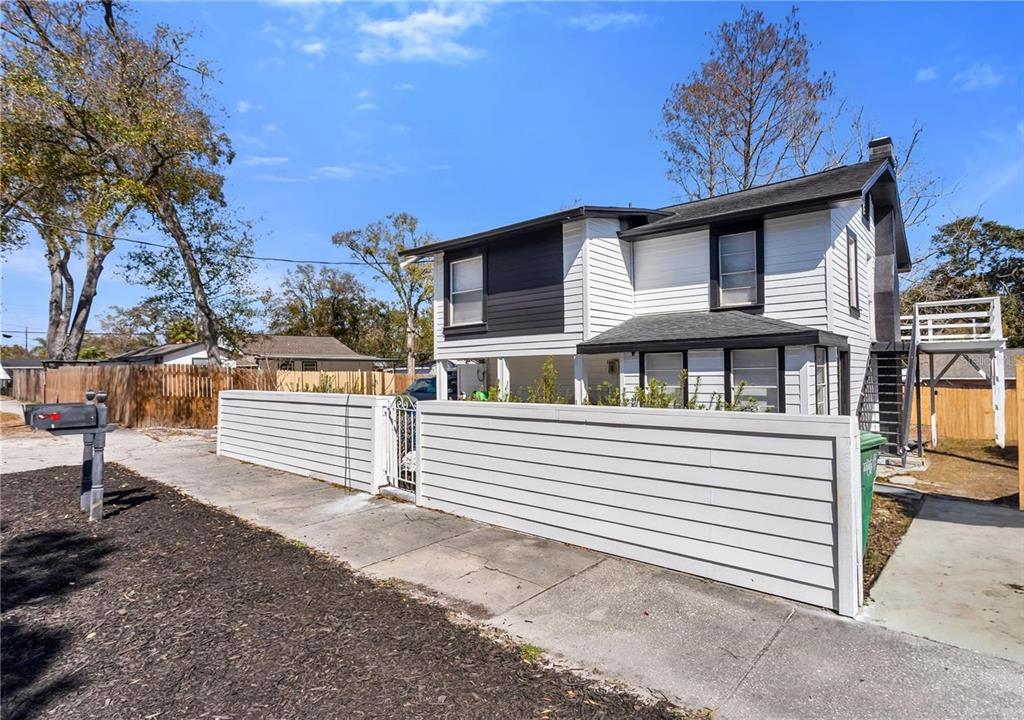 A two-story white house with black trim and a horizontal wooden privacy fence — 4103 N HOWARD AVENUE UNIT A, TAMPA, FL