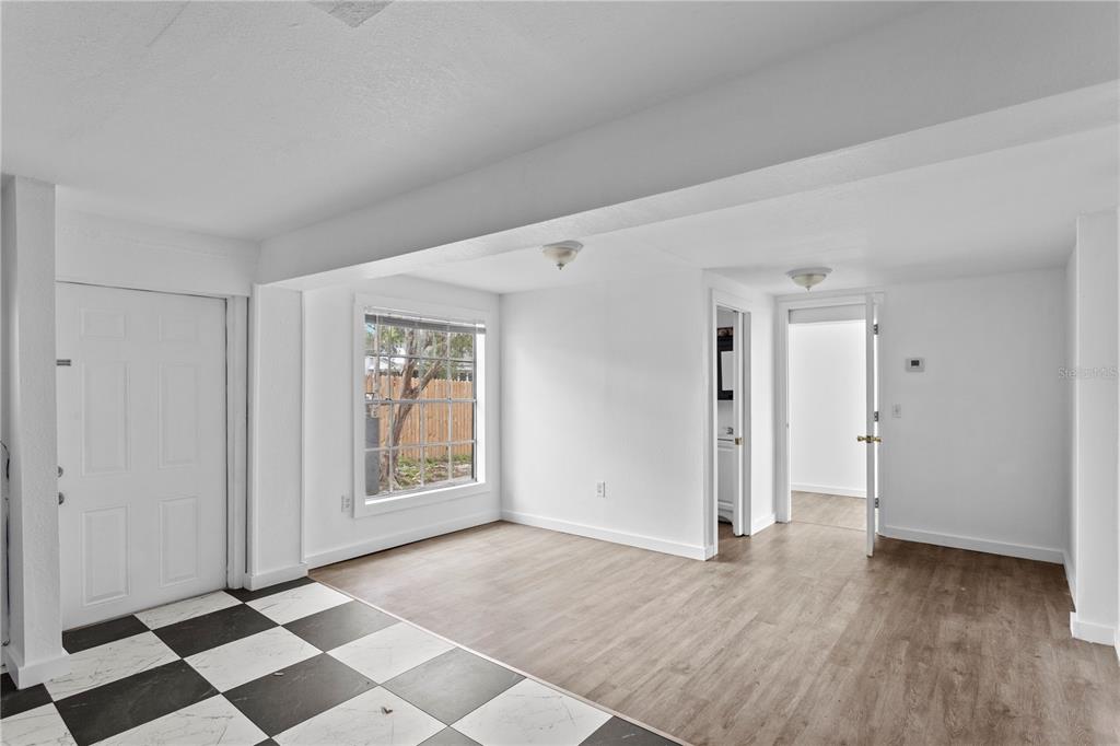 A room with a checkered floor, wood-look flooring, white walls, and two doorways — 4103 N HOWARD AVENUE UNIT A, TAMPA, FL