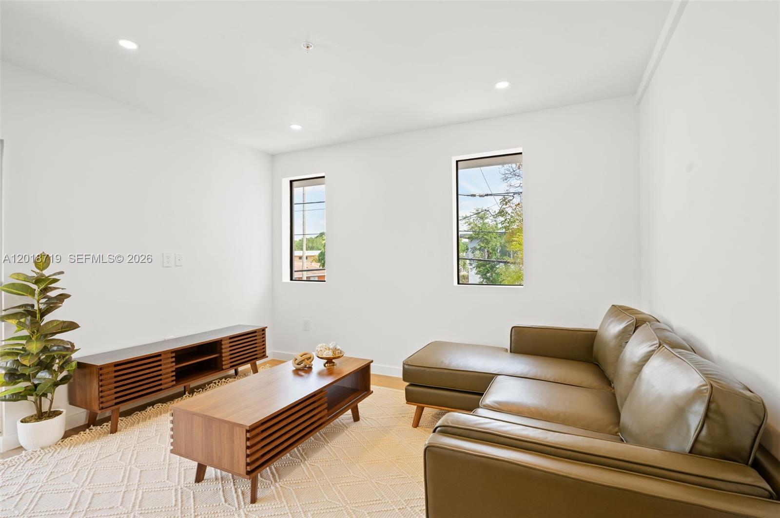 A living room features a leather sectional, a wooden coffee table, and a media console — 722 NW 55th Ter # 722, Miami FL 33127, MIAMI, FL