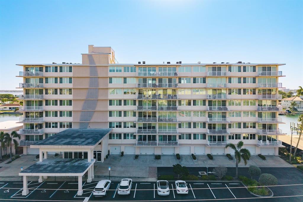 An exterior view of a multi-story apartment building with balconies and a covered entrance — 223 ISLAND WAY UNIT 2D, CLEARWATER BEACH, FL