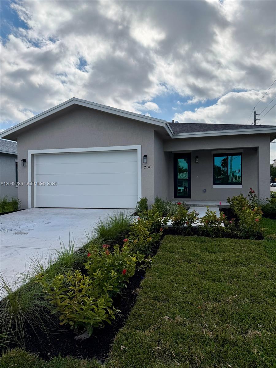 A single-story house with a white garage door, gray exterior, and a landscaped front yard — 288 SW 2nd Ct, Deerfield Beach FL 33441, DEERFIELD BEACH, FL