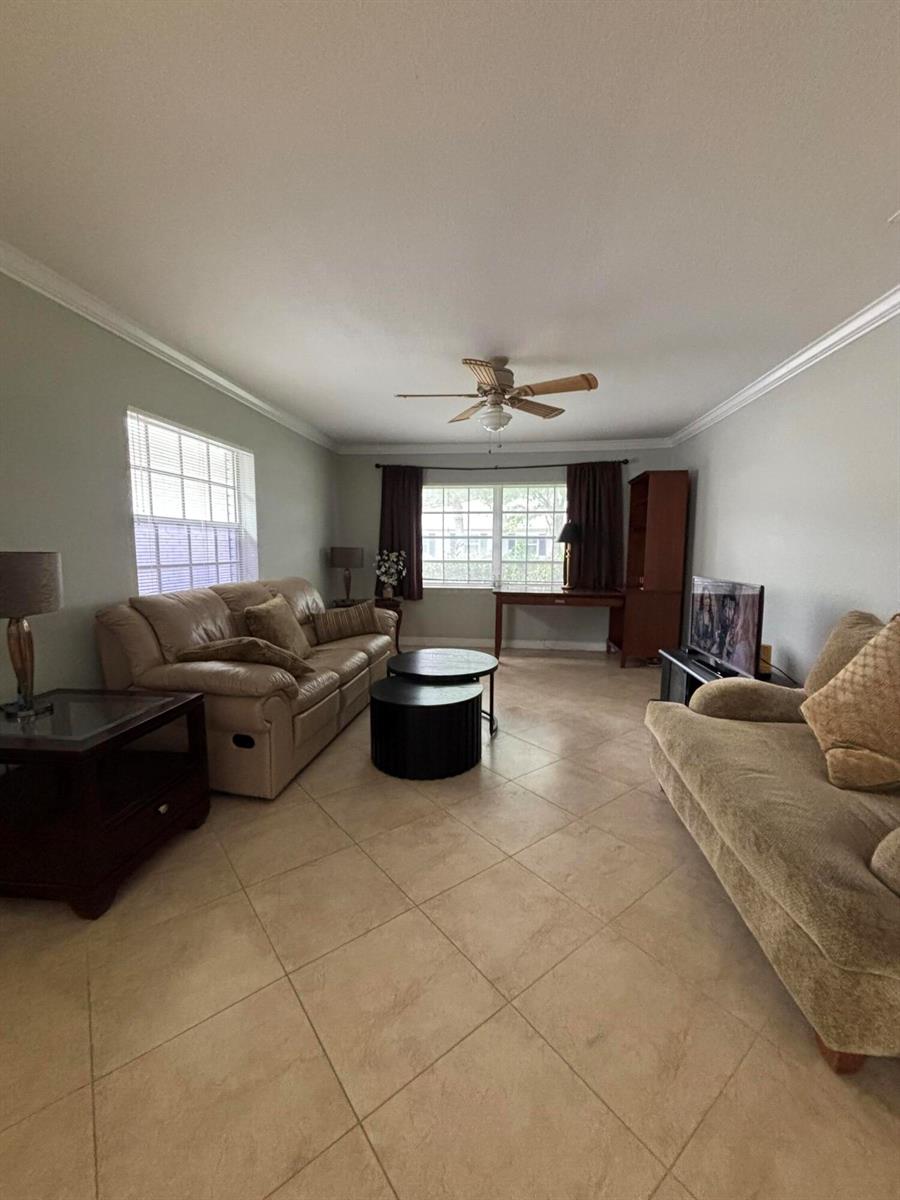 A living room features tile floors, two sofas, a coffee table, and a ceiling fan — 10084 S 42nd Dr Drive # 122, Boynton Beach FL 33436, BOYNTON BEACH, FL