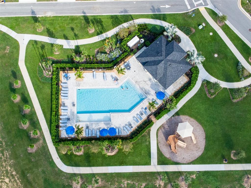 An aerial view shows a community swimming pool, a clubhouse, and a playground — 757 STONEY POINT CIRCLE, DAVENPORT, FL