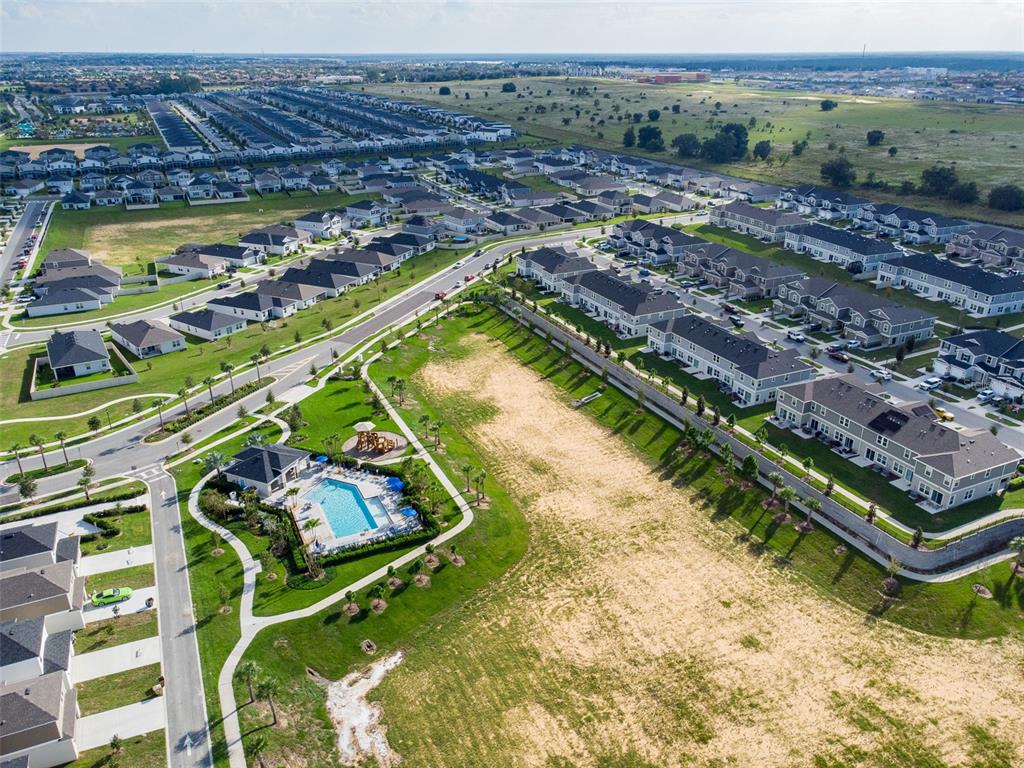 Aerial view of a suburban neighborhood featuring a community pool, playground, and residential houses — 757 STONEY POINT CIRCLE, DAVENPORT, FL