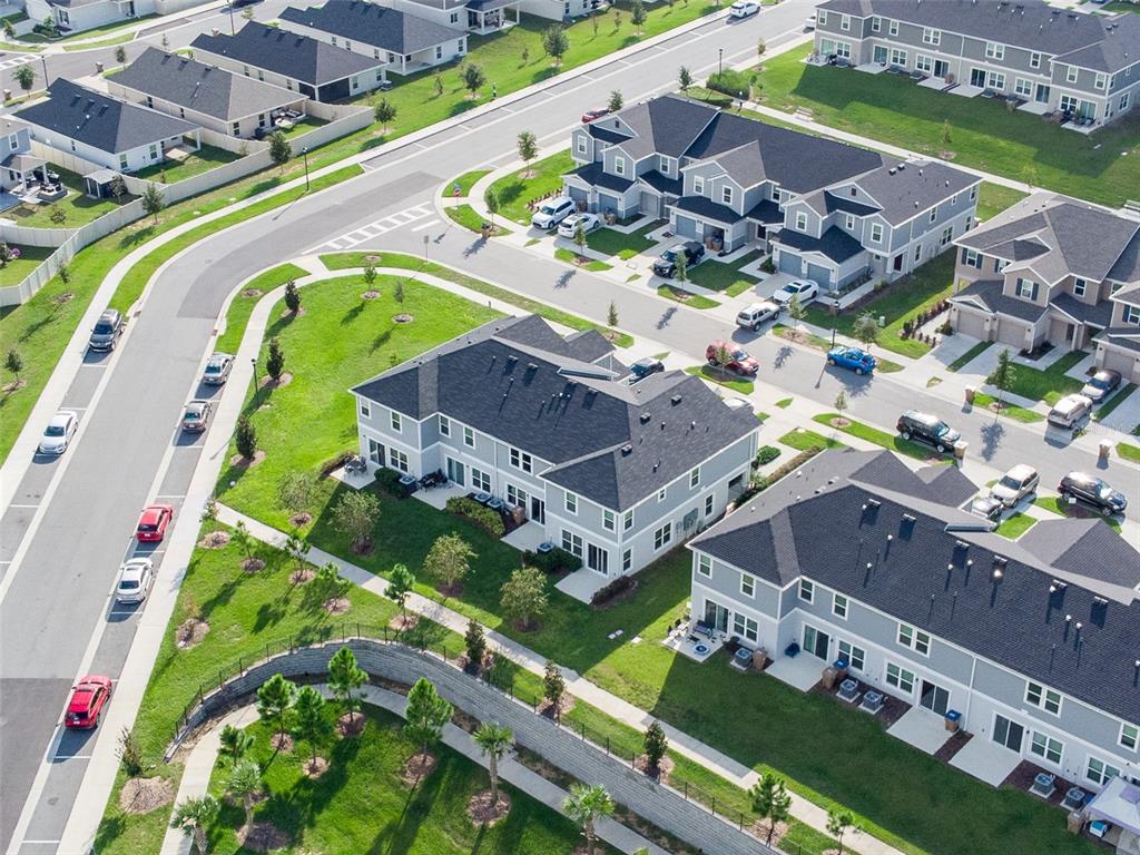 An aerial view shows multiple multi-family residential buildings surrounded by green lawns and paved streets — 757 STONEY POINT CIRCLE, DAVENPORT, FL