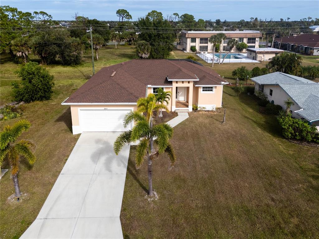 An aerial view shows a single-story house with a brown roof and a concrete driveway — 241 ANNAPOLIS LANE, ROTONDA WEST, FL