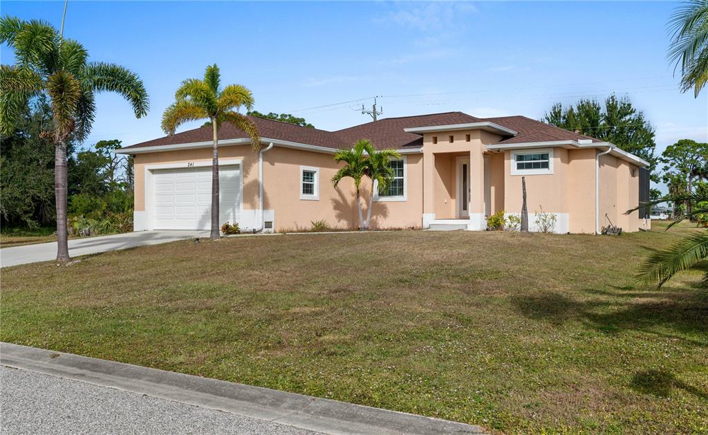 A single-story peach-colored house with a two-car garage and palm trees in the front yard — 241 ANNAPOLIS LANE, ROTONDA WEST, FL