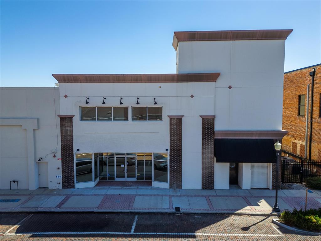 A two-story commercial building with a brick-accented facade and glass storefront entrance — 106 N EVERS STREET, PLANT CITY, FL