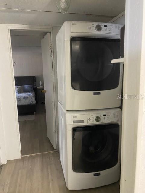 A stacked washer and dryer unit stands in a hallway next to a bedroom doorway — 2789 MERIDITH LANE, PONCE DE LEON, FL