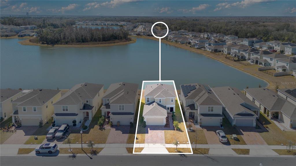 An aerial view shows a two-story house with a paved driveway facing a lake — 5018 ROYAL POINT AVENUE, KISSIMMEE, FL