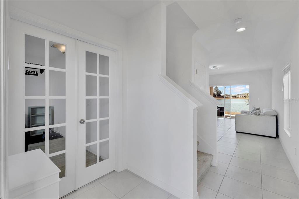 A white-walled entryway leads to a living area with tile floors and a water view — 5018 ROYAL POINT AVENUE, KISSIMMEE, FL