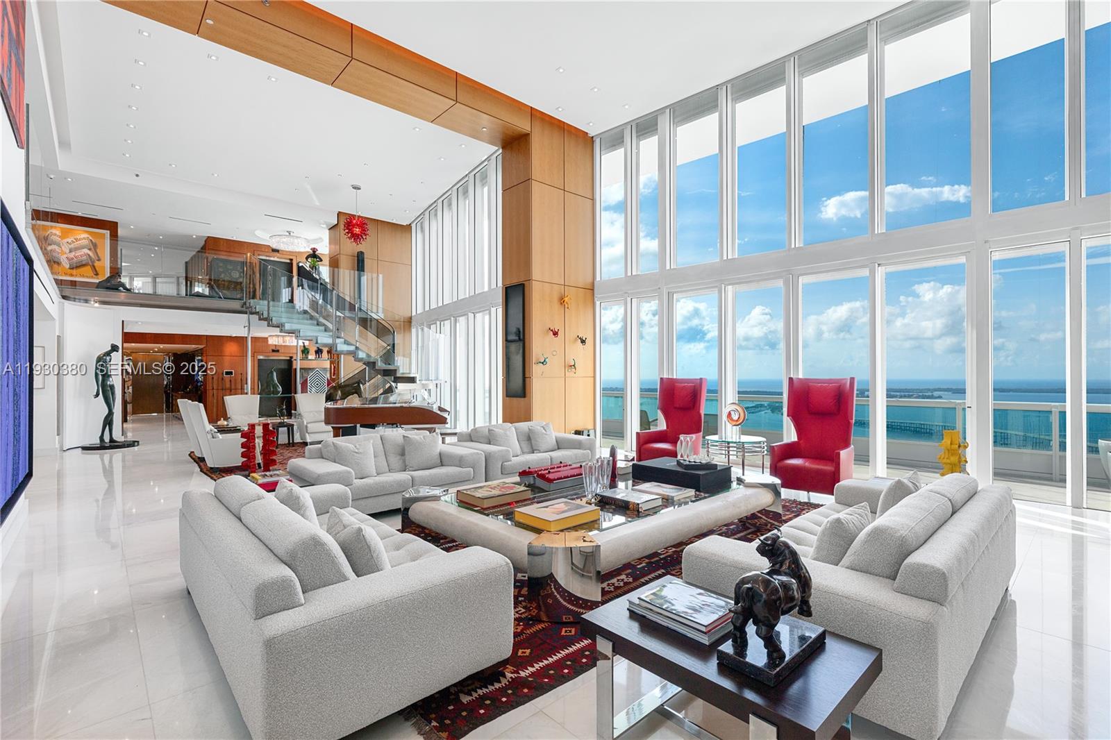 A spacious, high-ceilinged living room features floor-to-ceiling windows with ocean views and modern furniture — 1643 Brickell Ave, Miami FL 33129, MIAMI, FL