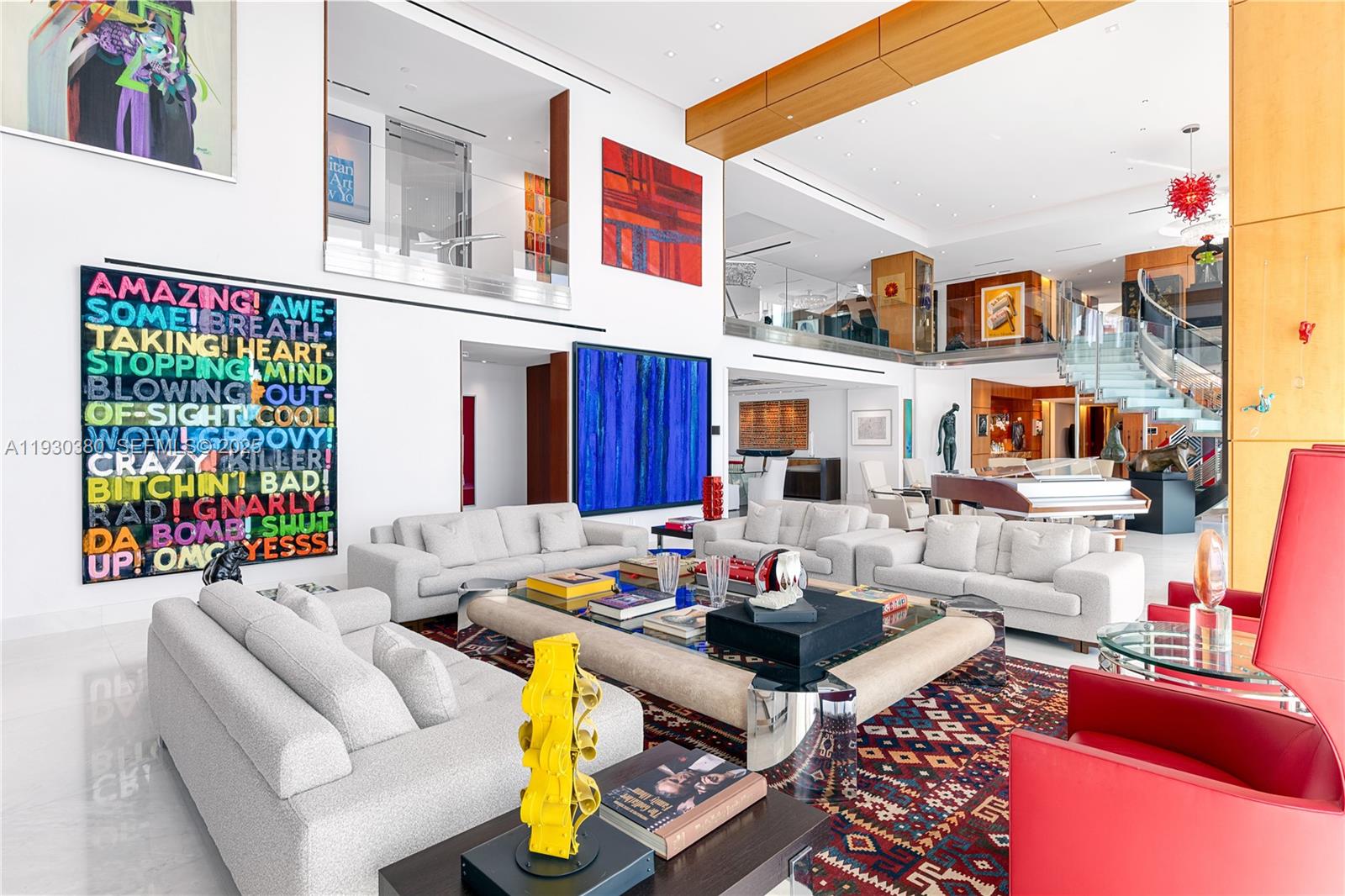 A spacious, high-ceilinged living room features white sofas, a large area rug, and modern art — 1643 Brickell Ave, Miami FL 33129, MIAMI, FL