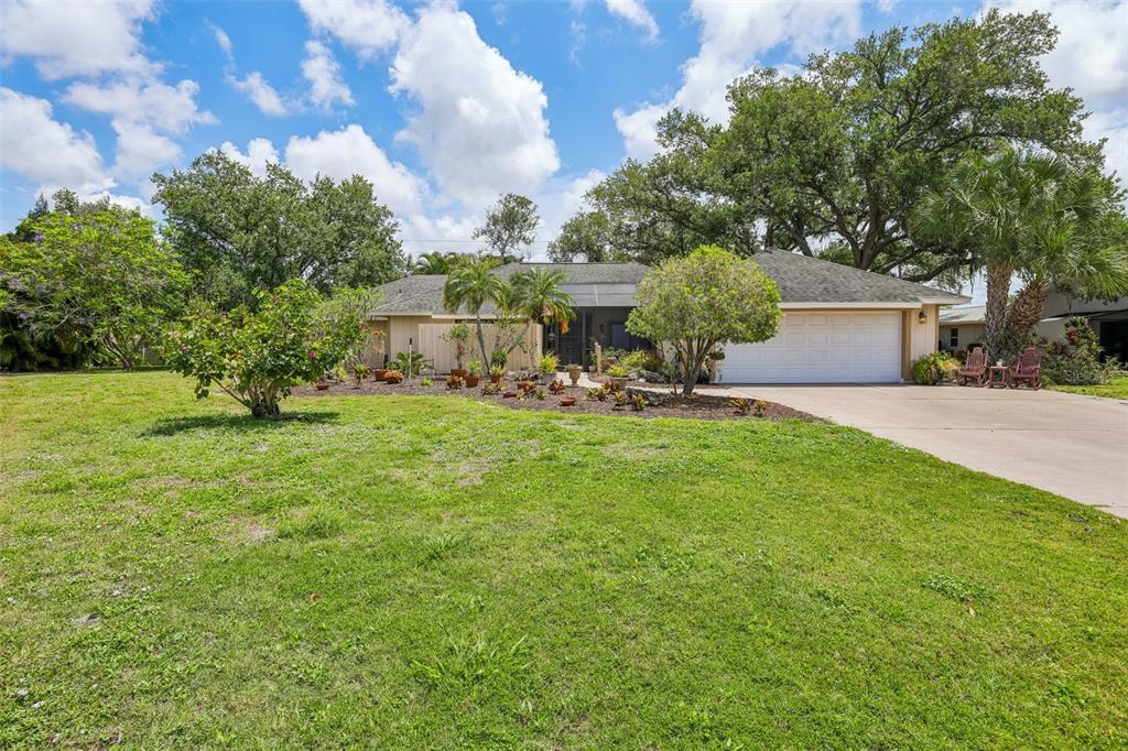 A kitchen features white cabinets, dark granite countertops, stainless steel appliances, and a breakfast bar — 3757 COUNTRYSIDE ROAD, SARASOTA, FL