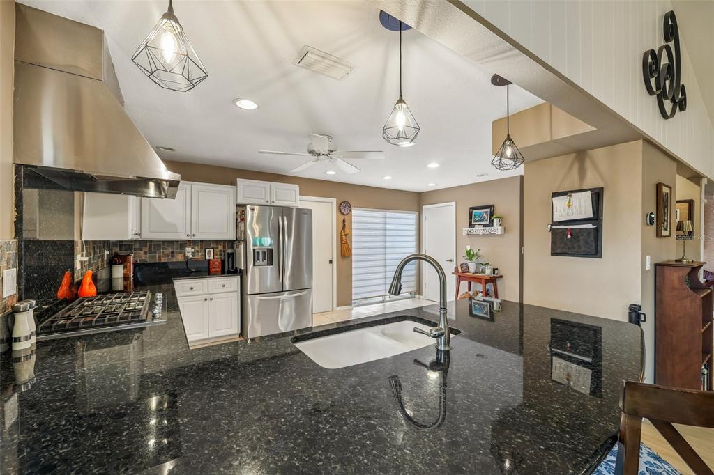A living room features light wood flooring, a fireplace, built-in shelving, and a vaulted ceiling — 3757 COUNTRYSIDE ROAD, SARASOTA, FL