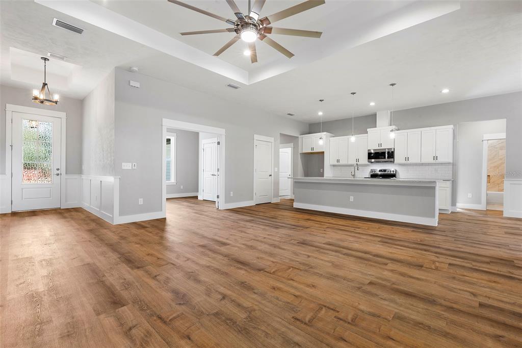 An open-concept living area features wood-look flooring, a tray ceiling, and a white kitchen — 0 SW KIMBERLY LANE LOT 6 DRIVE, LAKE CITY, FL