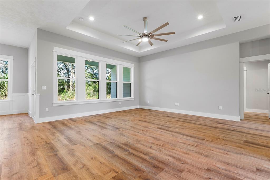 A spacious living room features light gray walls, wood-look flooring, and a tray ceiling — 0 SW KIMBERLY LANE LOT 6 DRIVE, LAKE CITY, FL