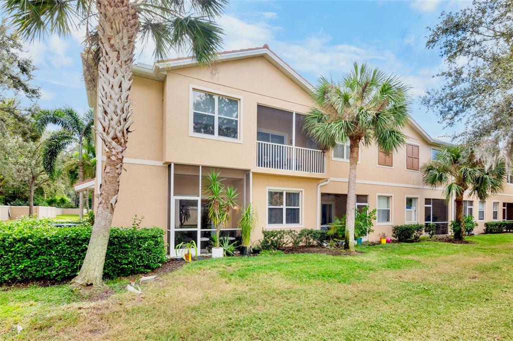 A two-story tan stucco townhouse features a screened-in patio and balcony with palm trees — 3537 PARKRIDGE CIRCLE UNIT 15-106, SARASOTA, FL