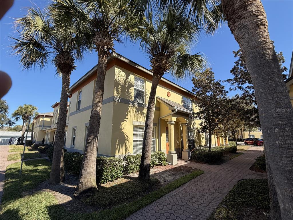 A two-story yellow stucco building features palm trees and a paved walkway in front — 3858 ISLAND WAY, ST PETERSBURG, FL