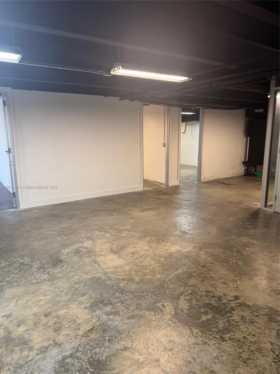 An interior room features white walls, a stained concrete floor, and exposed ceiling lighting — 4751 W Flagler St, Miami FL 33134, MIAMI, FL